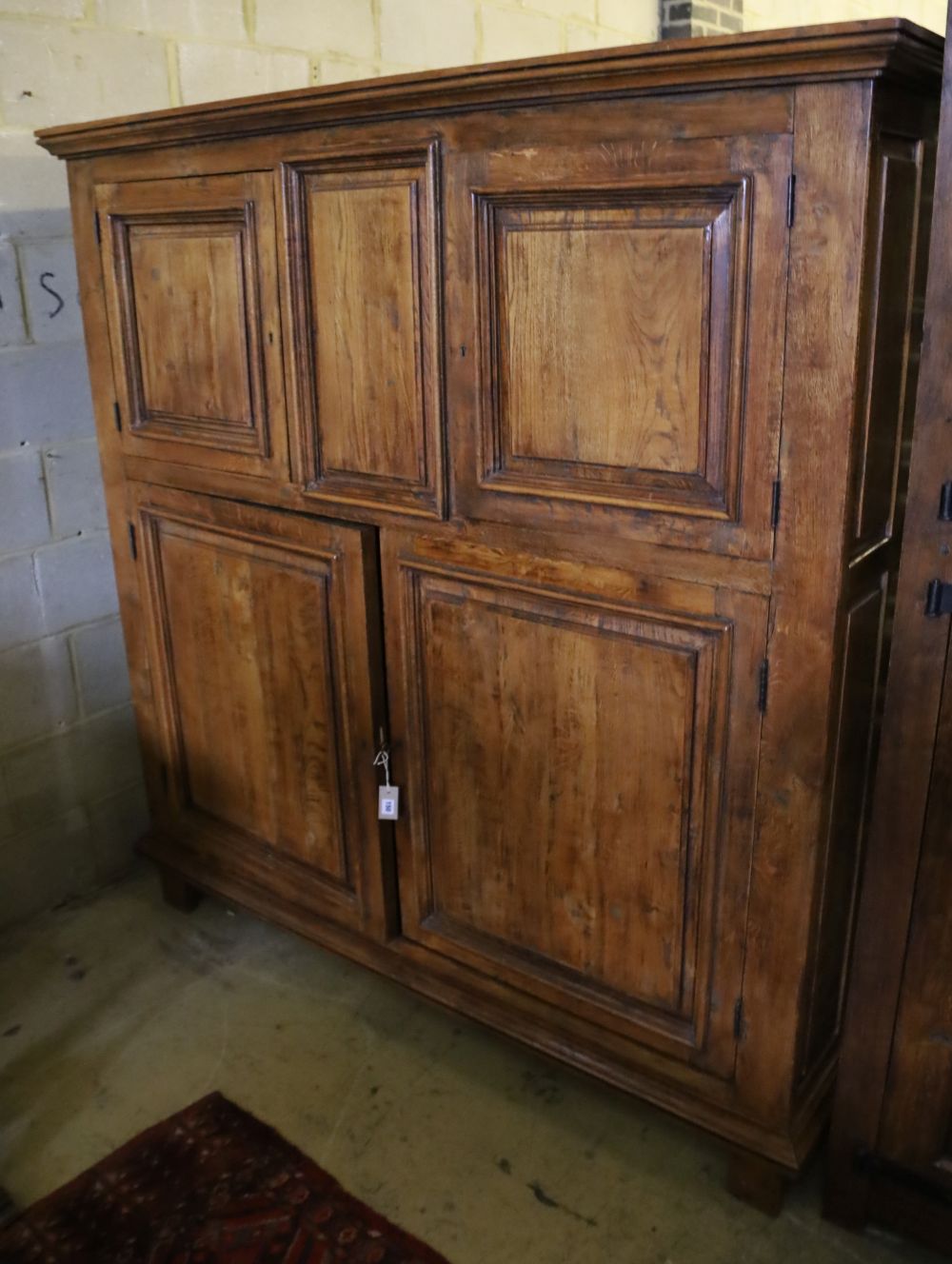 A 19th century French panelled walnut press cupboard fitted upper and lower pairs of doors, width 172cm, depth 52cm, height 181cm